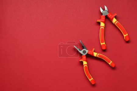 Photo for Pliers on red background, flat lay. Space for text - Royalty Free Image