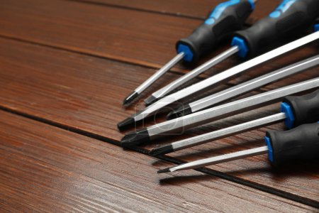 Set of screwdrivers on wooden table, closeup. Space for text