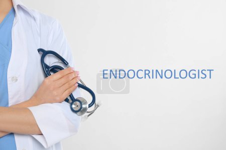 Endocrinologist with stethoscope on light grey background, closeup