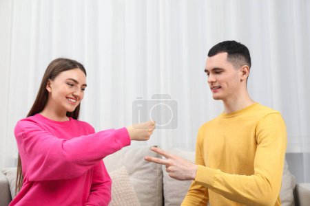 Photo for Happy people playing rock, paper and scissors in room - Royalty Free Image