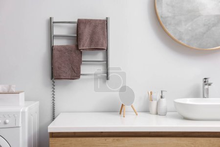 Photo for Heated towel rail with brown towels in bathroom - Royalty Free Image
