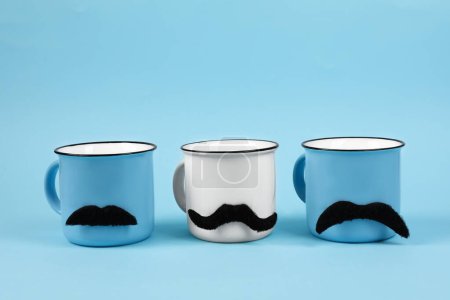 Téléchargez les photos : Tasses avec de fausses moustaches sur fond bleu clair - en image libre de droit