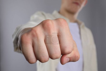 Man showing fist with space for tattoo on grey background, selective focus