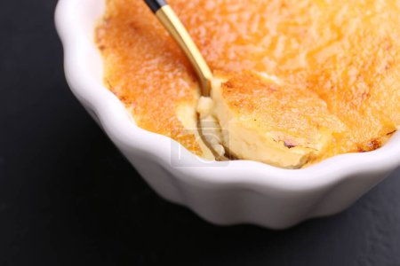 Foto de Deliciosa crema brulee en tazón servido en la mesa gris oscuro, primer plano - Imagen libre de derechos