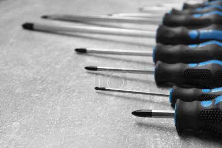 Set of screwdrivers on grey table, closeup