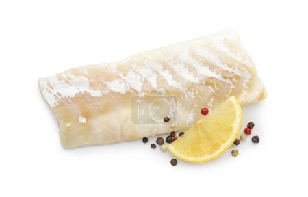 Foto de Filete fresco de bacalao crudo con granos de pimienta y limón aislado en blanco - Imagen libre de derechos