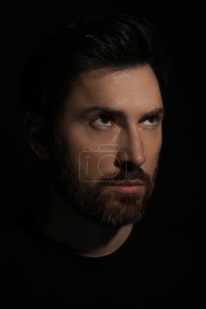 Photo for Evil eye. Man with scary eyes in darkness, closeup - Royalty Free Image