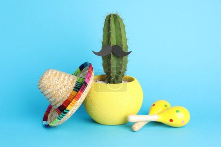 Téléchargez les photos : Chapeau sombrero mexicain, cactus avec fausse moustache et maracas sur fond bleu clair - en image libre de droit