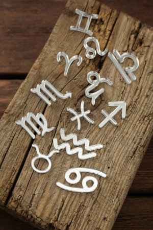 Zodiac signs on wooden table, above view