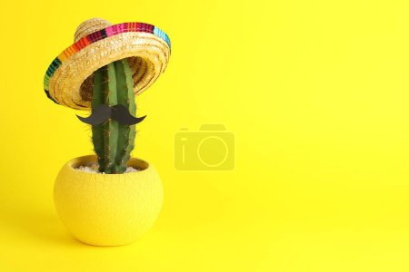 Téléchargez les photos : Cactus avec chapeau de sombrero mexicain et fausse moustache sur fond jaune, espace pour le texte - en image libre de droit