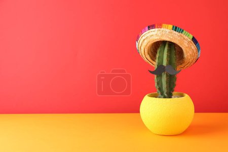 Téléchargez les photos : Cactus avec chapeau de sombrero mexicain et fausse moustache sur fond de couleur. Espace pour le texte - en image libre de droit