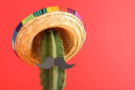 Téléchargez les photos : Cactus avec chapeau de sombrero mexicain et fausse moustache sur fond rouge. Espace pour le texte - en image libre de droit
