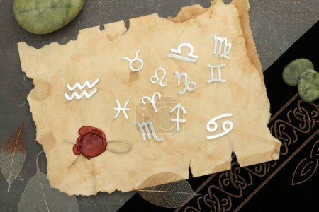 Flat lay composition with zodiac signs on grey textured table