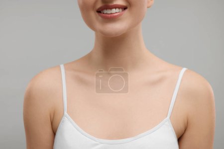 Beauty concept. Smiling woman on grey background, closeup