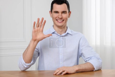 Foto de Hombre saludando mientras tiene video chat en el interior, vista desde la cámara web - Imagen libre de derechos