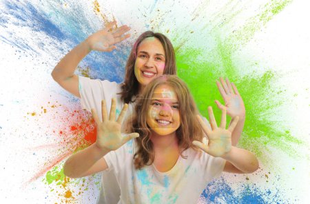 Téléchargez les photos : Fête du festival Holi. Femme heureuse et fille couverte de colorants en poudre colorés sur fond blanc - en image libre de droit