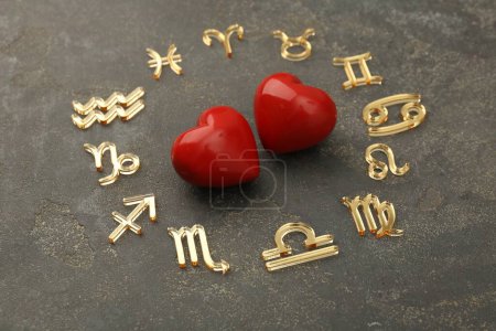 Zodiac signs and red hearts on grey textured background