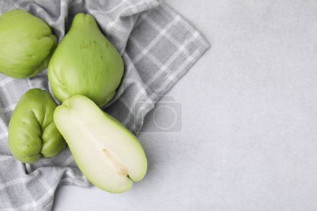 Photo for Cut and whole chayote on gray table, top view. Space for text - Royalty Free Image