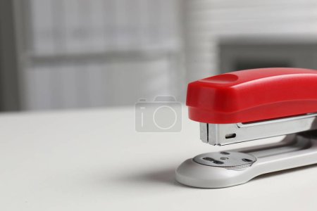 One stapler on white table, closeup. Space for text