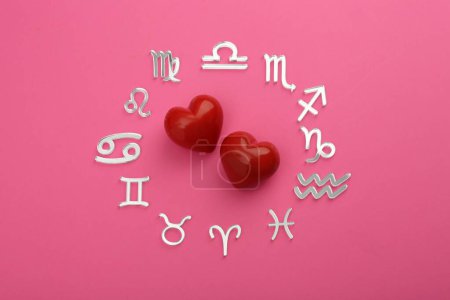 Foto de Signos del zodíaco y corazones rojos sobre fondo rosa, acostado plano - Imagen libre de derechos