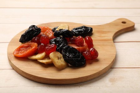 Téléchargez les photos : Mélange de délicieux fruits secs sur une table en bois blanc - en image libre de droit