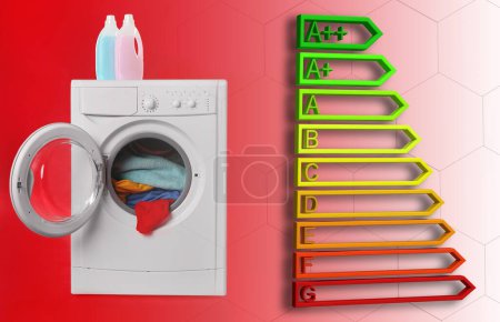 Foto de Etiqueta de eficiencia energética y lavadora con lavandería sobre fondo rojo - Imagen libre de derechos