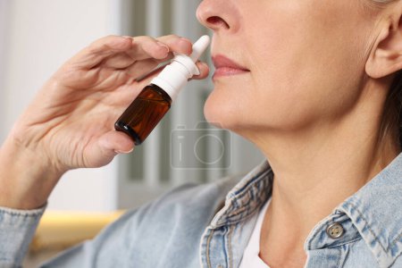Photo for Medical drops. Woman using nasal spray indoors, closeup - Royalty Free Image