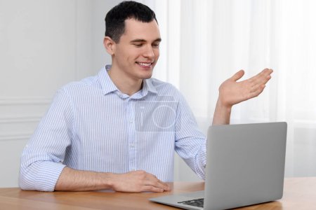 Foto de Hombre que tiene chat de vídeo en el ordenador portátil en interiores - Imagen libre de derechos