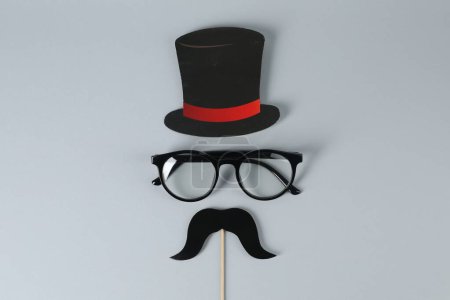 Téléchargez les photos : Fausse moustache avec accessoire de fête, chapeau en papier et lunettes sur fond gris, vue de dessus - en image libre de droit