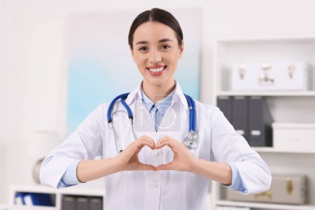 Téléchargez les photos : Médecin montrant un geste cardiaque avec les mains à la clinique - en image libre de droit