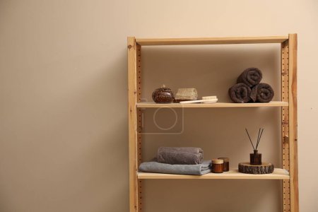 Weiche Handtücher, Kerzen, Lufterfrischer und Wellness-Produkte in den Regalen drinnen. Raum für Text