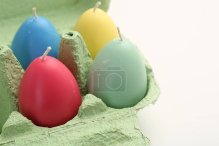 Téléchargez les photos : Bougies colorées en forme d'oeuf en carton sur table blanche, gros plan. Décor de Pâques - en image libre de droit