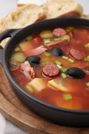 Téléchargez les photos : Soupe de viande solyanka avec de fines saucisses fumées sèches dans un bol sur la table, gros plan - en image libre de droit