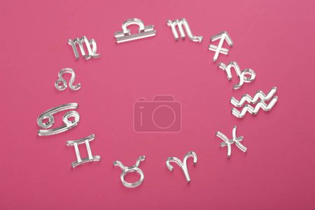 Zodiac signs on pink background, above view. Space for text