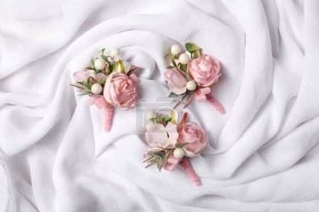 Téléchargez les photos : Boutonnières roses élégantes sur soie blanche, couché à plat - en image libre de droit