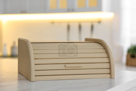 Wooden bread box on white table in kitchen, closeup