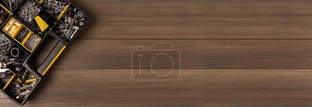 Photo for Box with different furniture fittings and tools on wooden table, top view. Banner design with space for text - Royalty Free Image