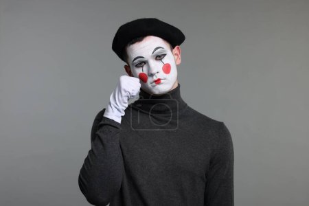Porträt des Pantomimen in Baskenmütze auf grauem Hintergrund