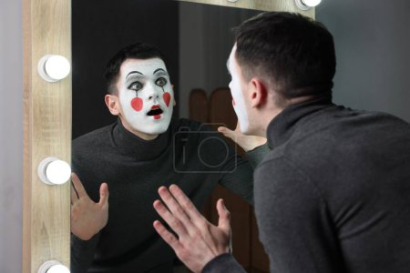 Mime artist posing near mirror in dressing room