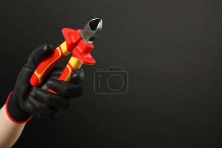 Photo for Woman with diagonal pliers on dark background, closeup. Space for text - Royalty Free Image