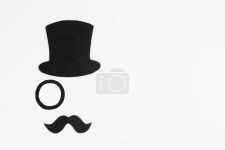 Téléchargez les photos : Fausse moustache, chapeau et monocle sur fond blanc, vue de dessus. Espace pour le texte - en image libre de droit
