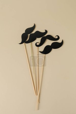 Téléchargez les photos : Faux papier moustaches accessoires de fête sur fond beige, pose plate - en image libre de droit