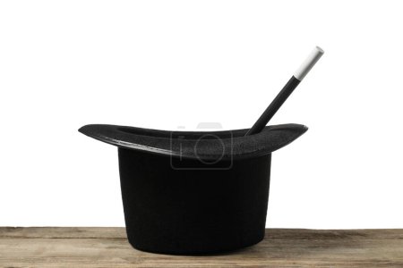 Sombrero de mago y varita sobre mesa de madera sobre fondo blanco