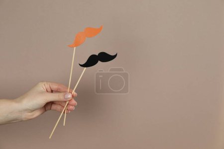 Photo for Woman with fake paper mustaches on beige background, closeup. Space for text - Royalty Free Image