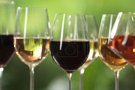 Photo for Different tasty wines in glasses against blurred background - Royalty Free Image