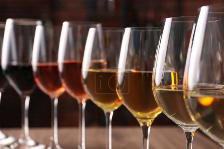 Photo for Different tasty wines in glasses against blurred background - Royalty Free Image
