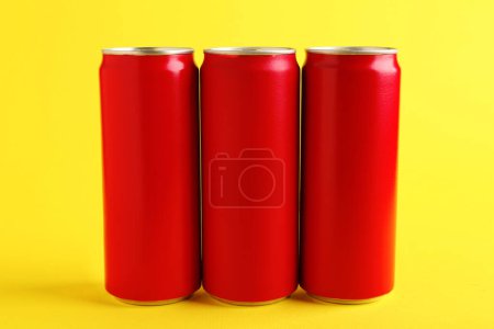 Foto de Bebidas energéticas en latas rojas sobre fondo amarillo - Imagen libre de derechos