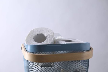 Téléchargez les photos : Rouleaux de papier toilette dans le panier contre le mur gris clair - en image libre de droit
