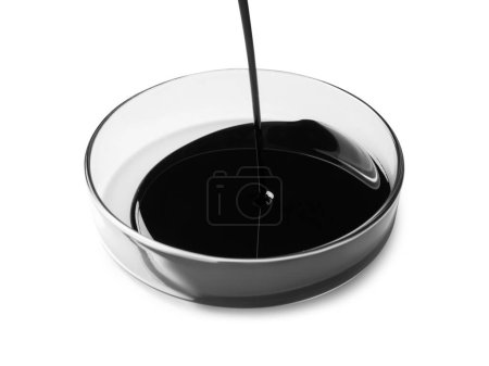 Photo for Pouring black crude oil into Petri dish on white background - Royalty Free Image