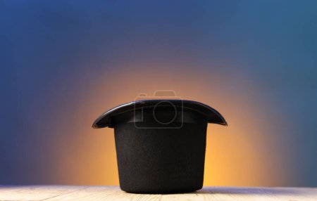 Sombrero de mago sobre mesa de madera sobre fondo de color